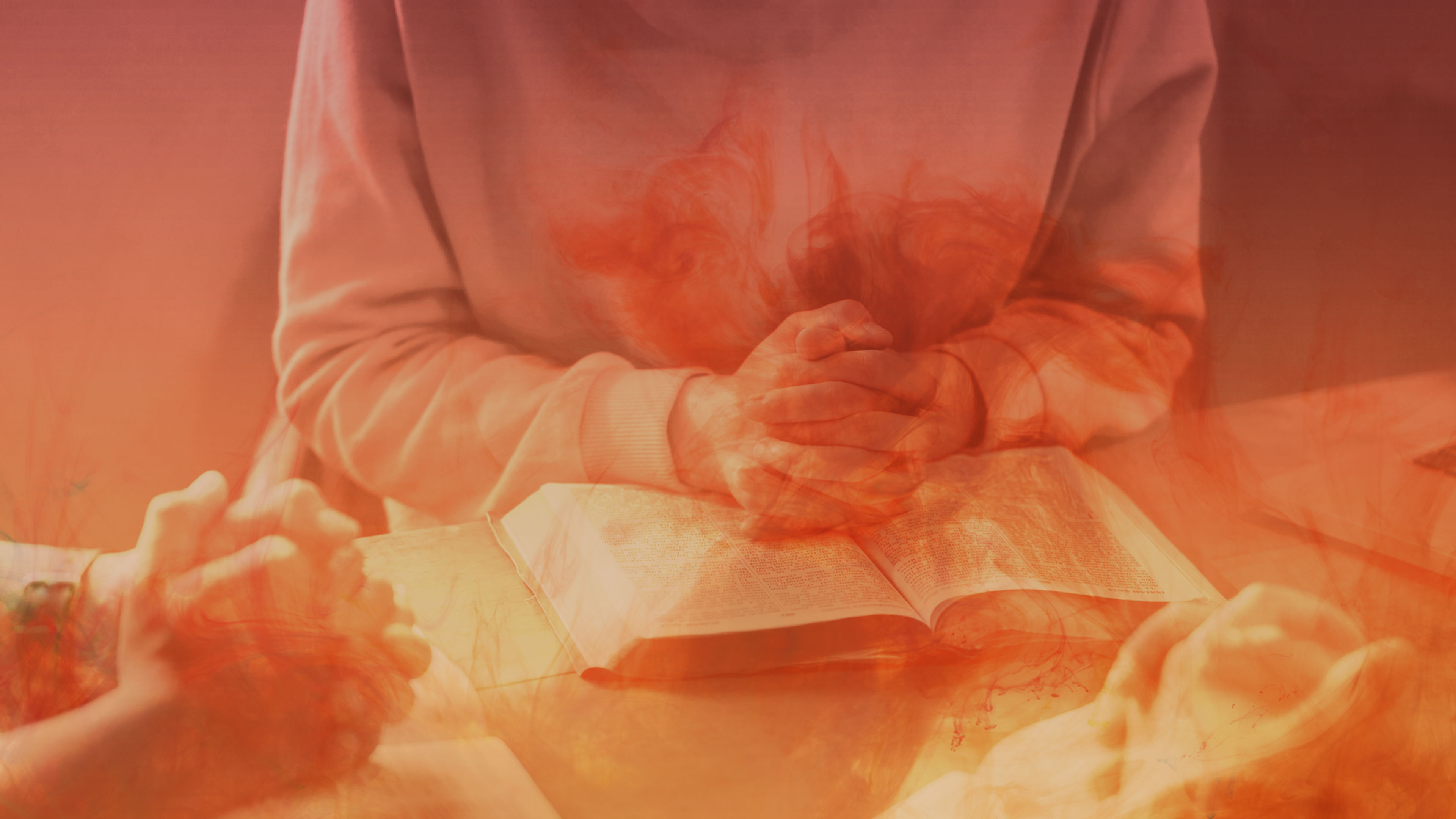 Praying Hands Over Bible with Fiery Effect